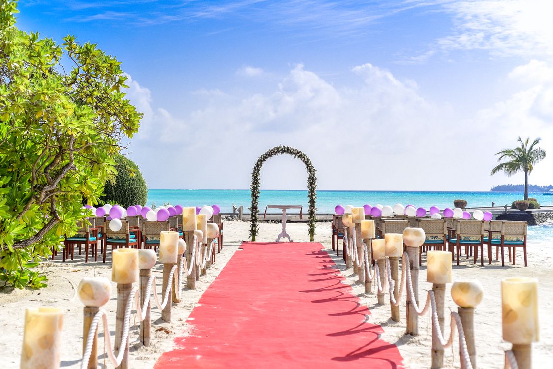 Tropical beach wedding ceremony under white clouds and blue sky