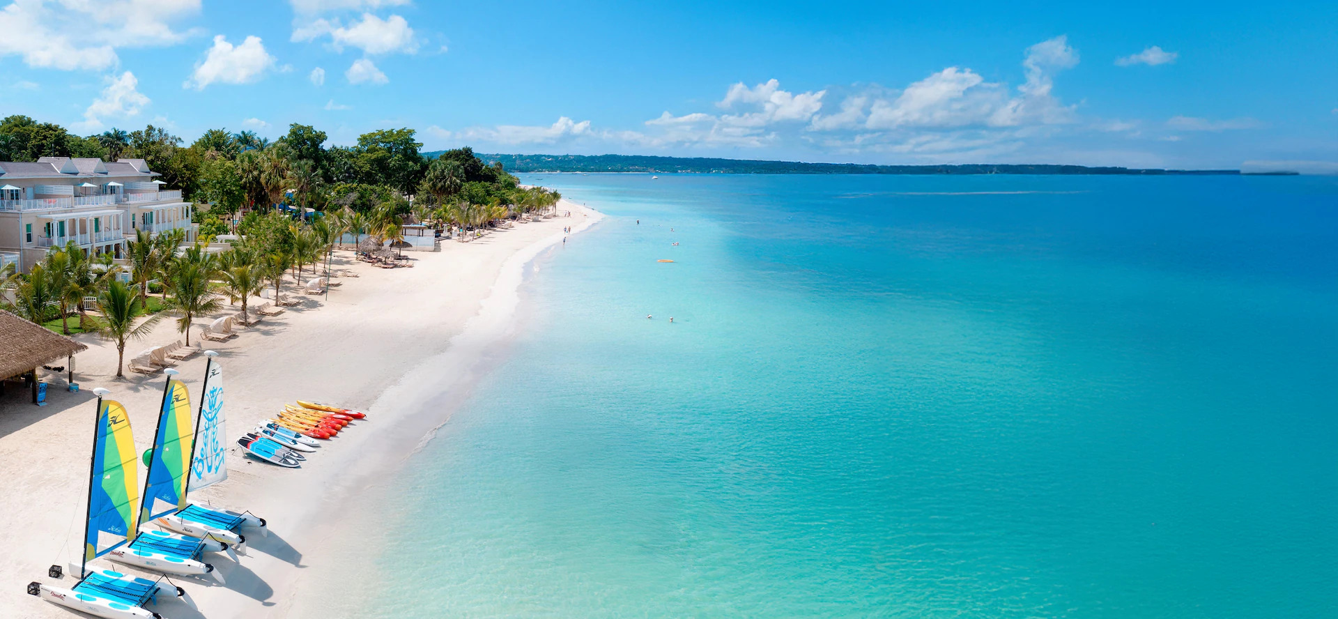 Beaches Negril wide-angle view of the resort along Seven Mile Beach with turquoise water and palm trees.