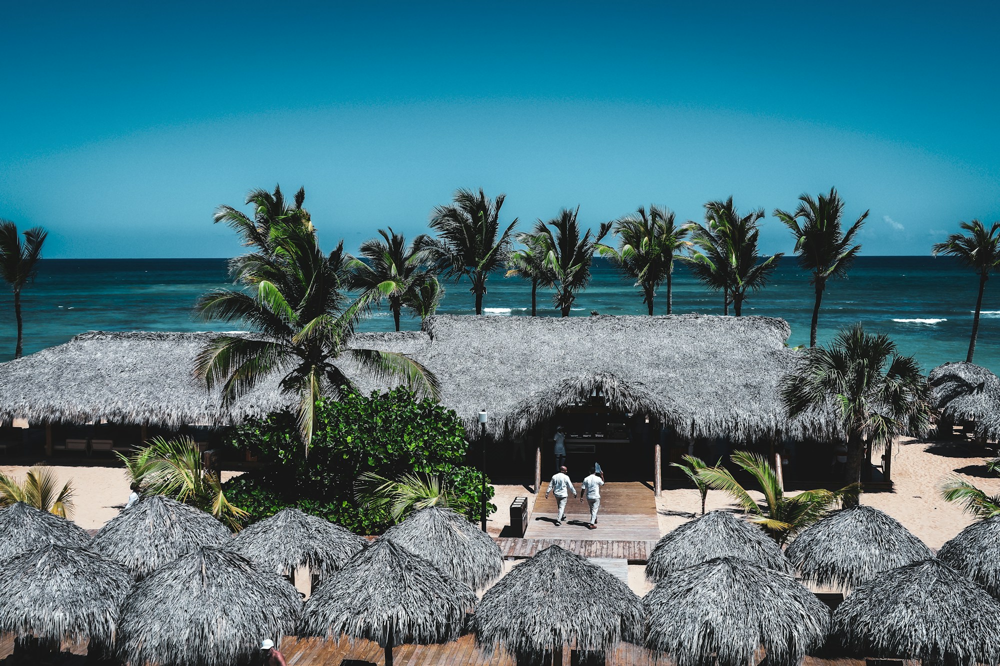 Tropical beach resort with thatched roofs and turquoise water