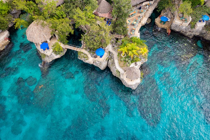 Negril cliffside resort with turquoise Caribbean water and rocky shoreline.
