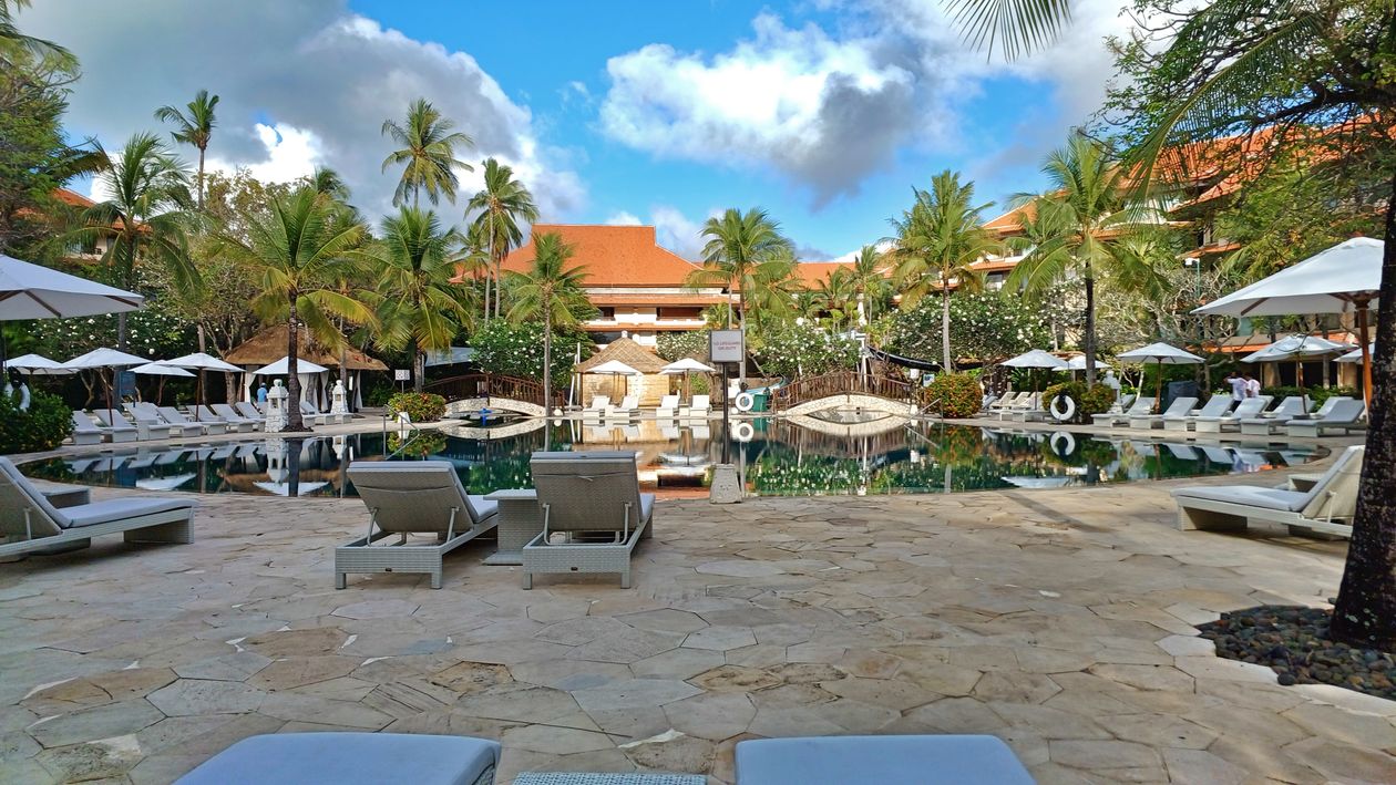 Luxurious poolside resort with lush gardens and clear blue sky