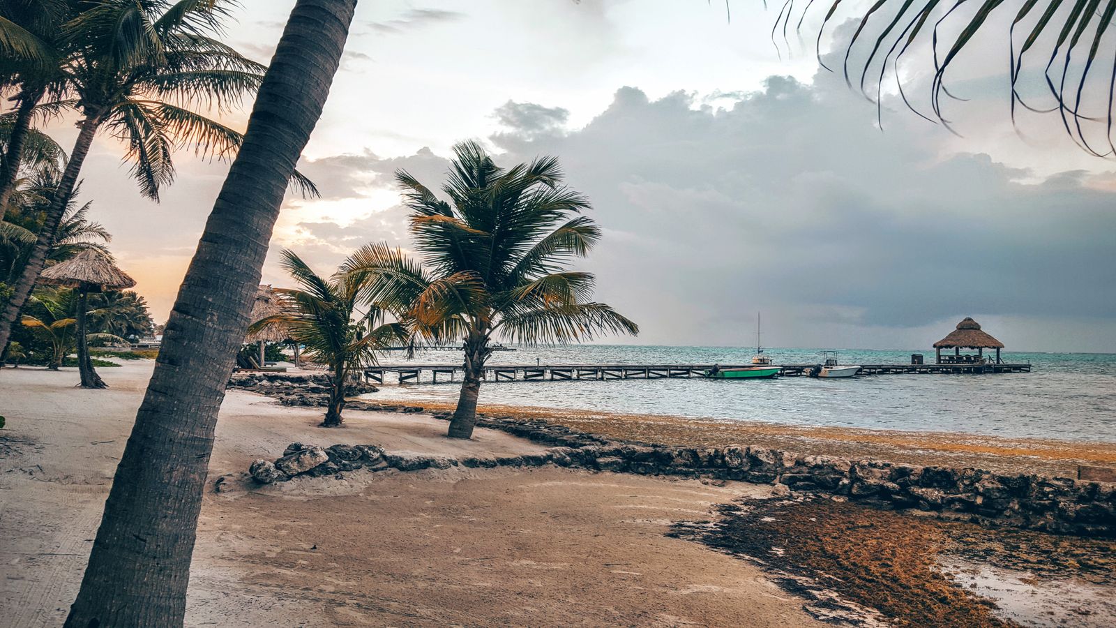 A wooden pier extending over calm Belizean water — the kind of waterfront access found at smaller island resorts.