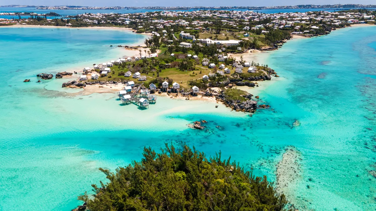 Aerial view of a sandy Caribbean coastline washed by turquoise waves.
