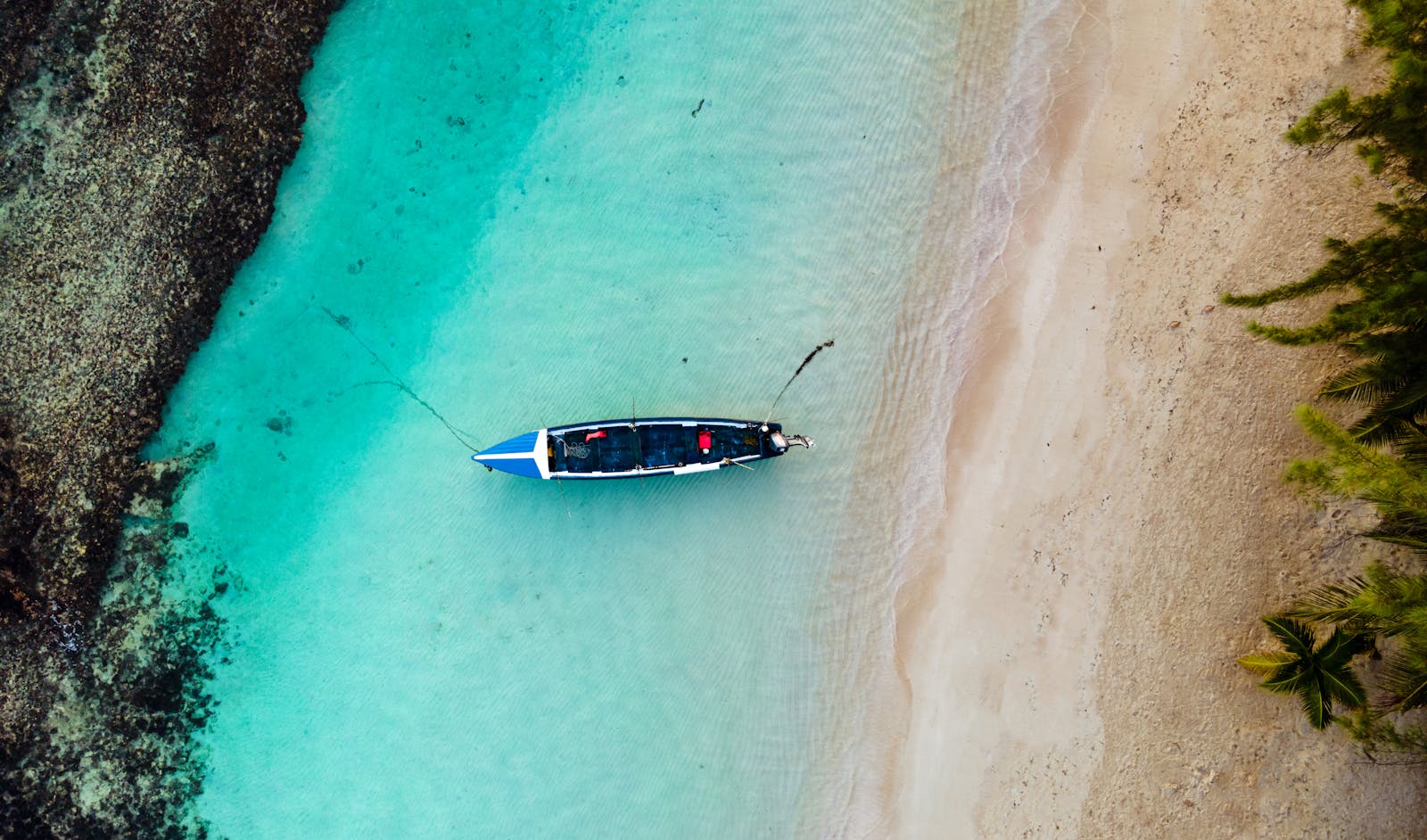 Overhead view of a lone boat in the clear turquoise waters of Ocho Rios, Jamaica.