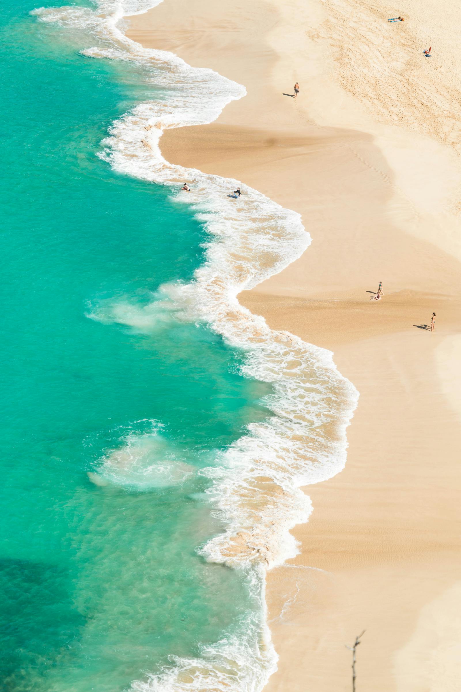 Aerial view of a tropical beach with white sand and turquoise water.