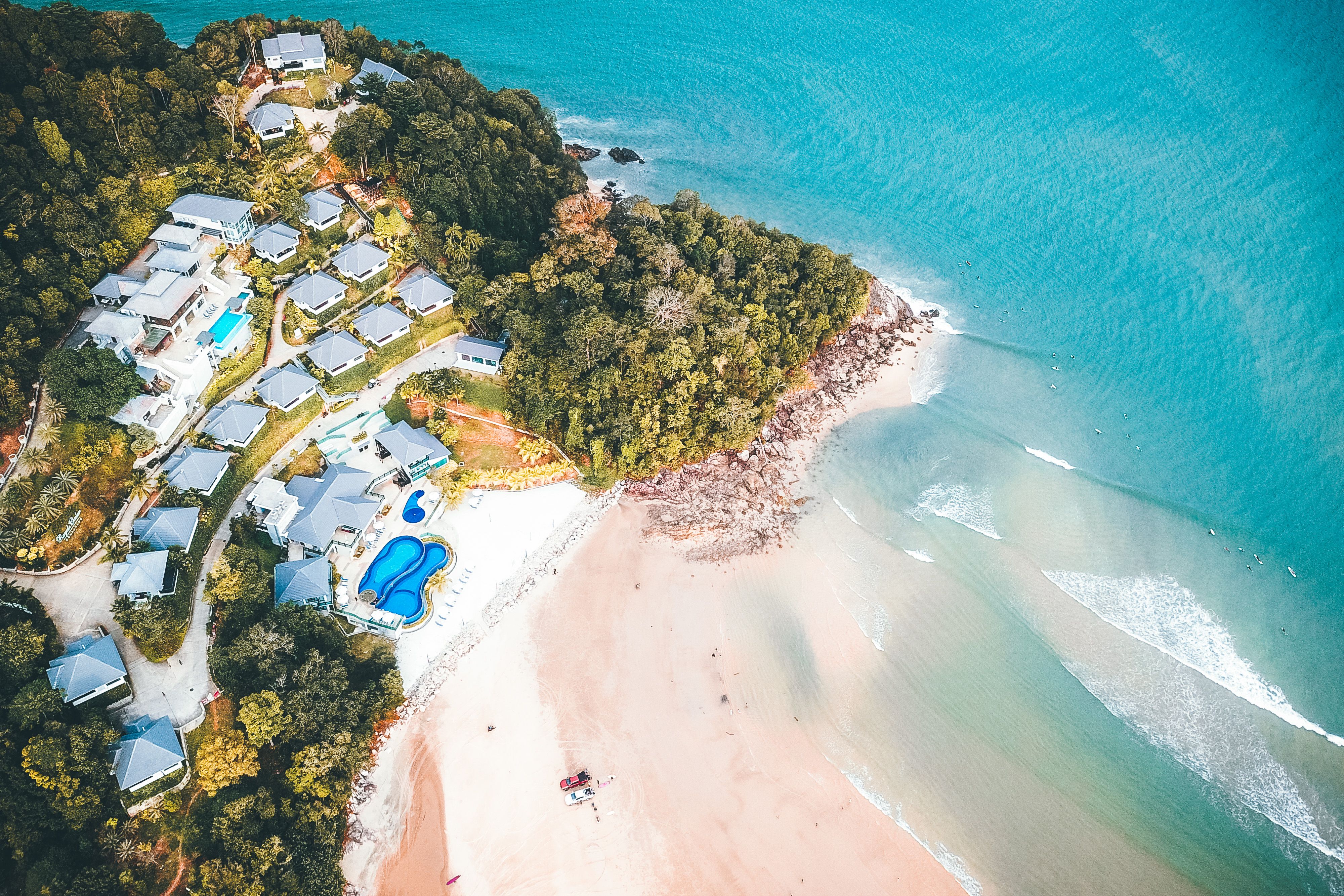 Tropical resort hotel surrounded by lush vegetation on a sandy Caribbean seashore.